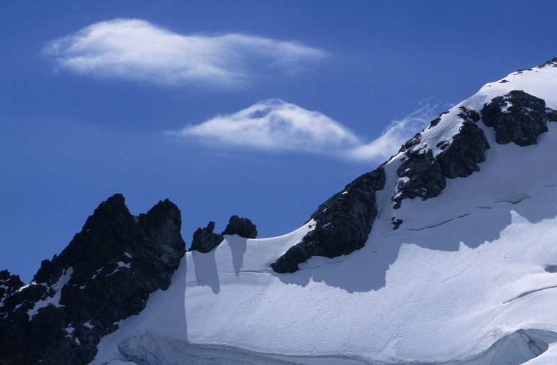 Banner cloud streaming horizontally from a sharp mountain peak like a flag