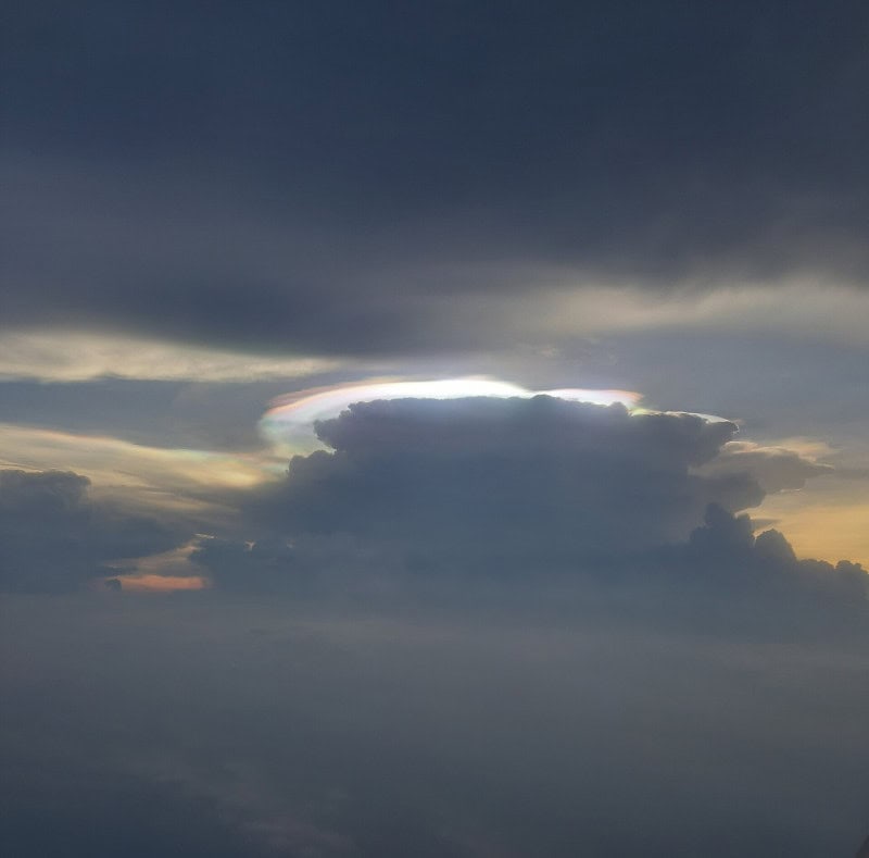 Cloud edge showing iridescent pastel rainbow colours near the sun