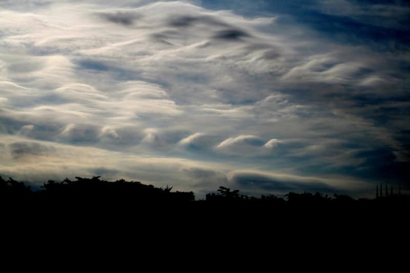 Kelvin-Helmholtz clouds forming a row of breaking wave shapes across the sky
