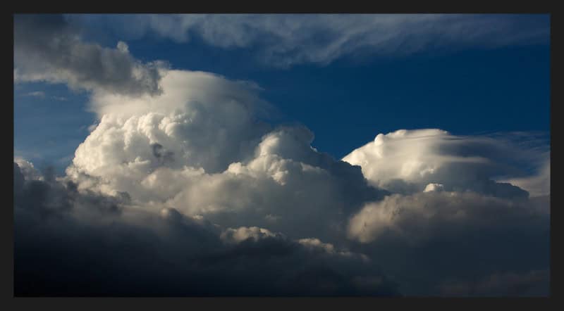 Smooth pileus cap cloud sitting like a hood above a rising cumulus tower