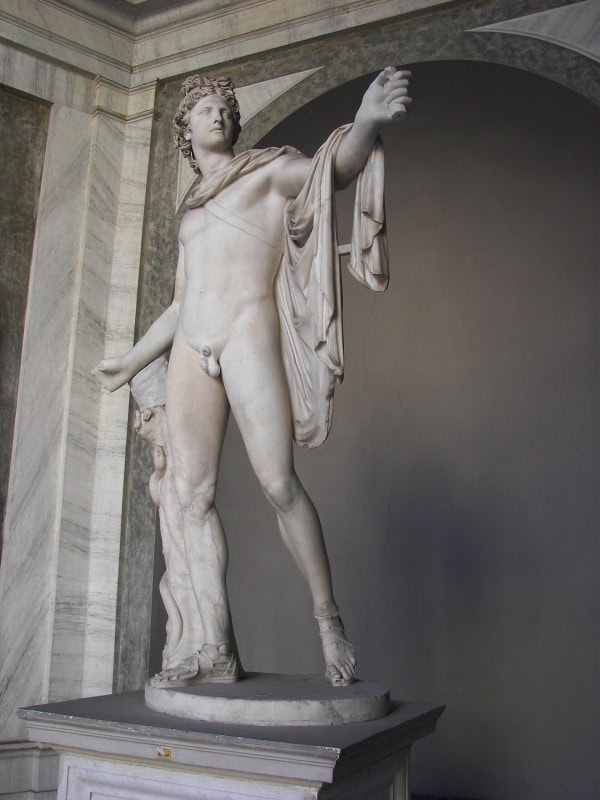 Marble Apollo striding forward with a cloak over his left shoulder and his left arm extended