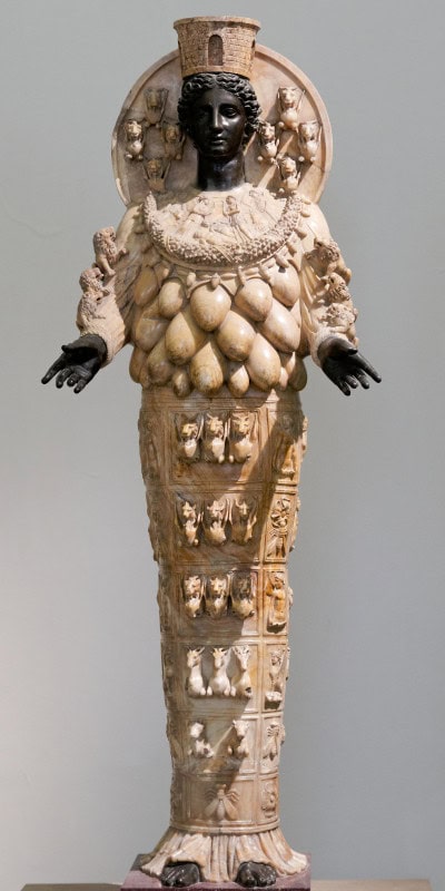 Statue of the Ephesian Artemis in pale alabaster with dark bronze head, hands and feet, her chest covered in rows of ovoid protuberances and her skirt carved with animals