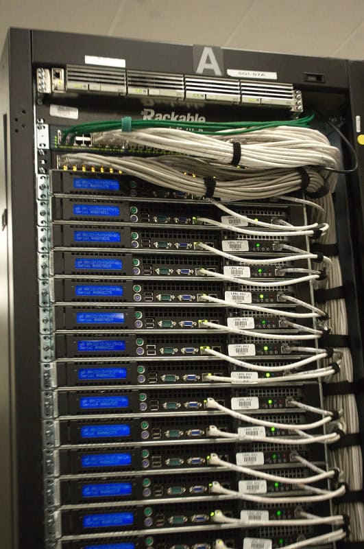 Rear view of server racks in a data centre, dense with blue and grey network cabling