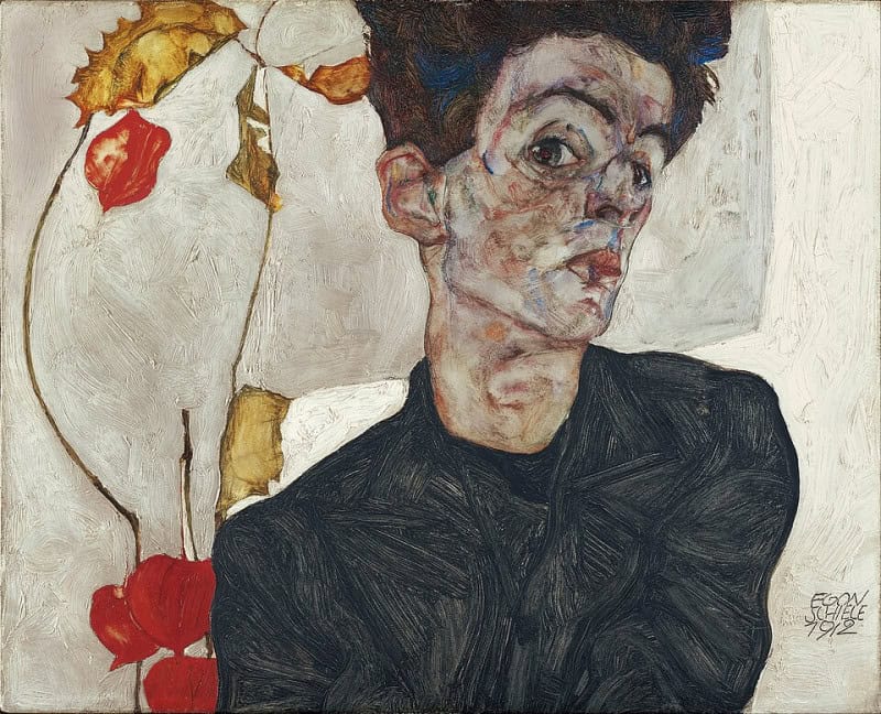 Gaunt young man with spiky dark hair in a dark patterned jacket, head tilted sharply and one shoulder hitched up, beside a thin stem carrying orange-red physalis pods and dry yellow-ochre leaves against a bare pale ground