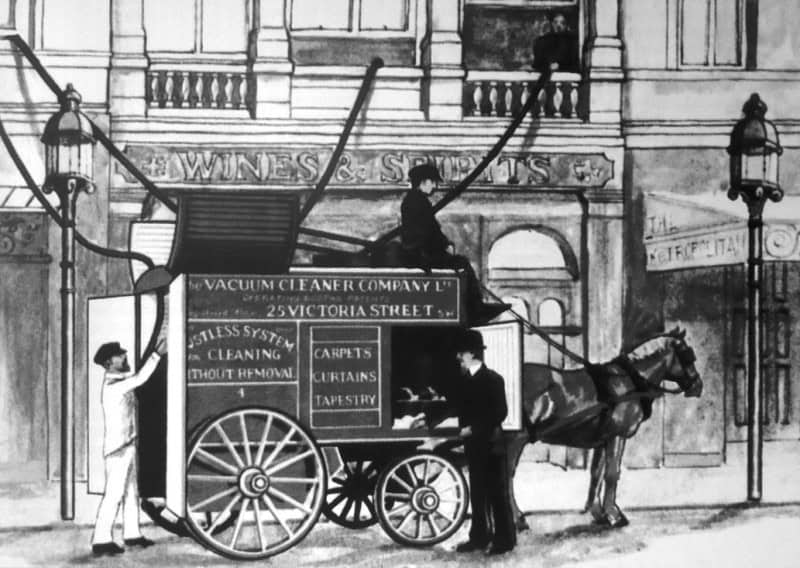 Period illustration of a horse-drawn van lettered "The Vacuum Cleaner Company Ltd", with hoses running from the van up into the upper-floor windows of a building