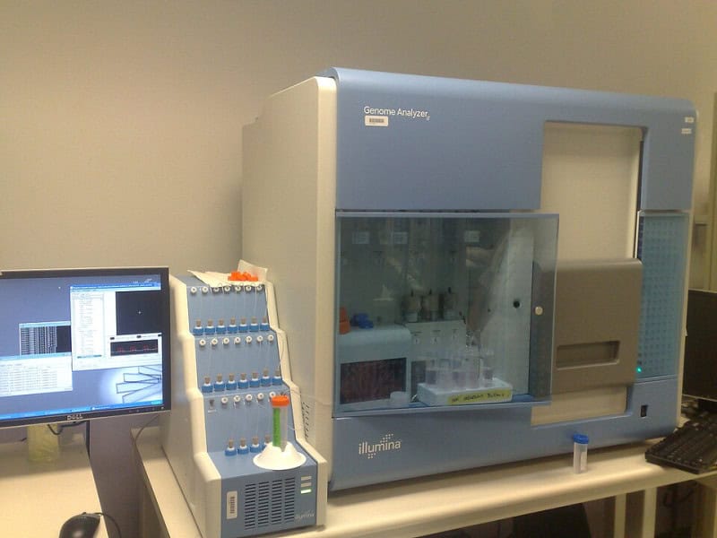 Illumina Genome Analyzer II sequencing machine, a grey benchtop instrument with an attached monitor, in a laboratory