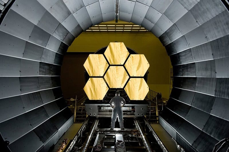 The gold-coated hexagonal segments of the James Webb Space Telescope primary mirror inside a test chamber