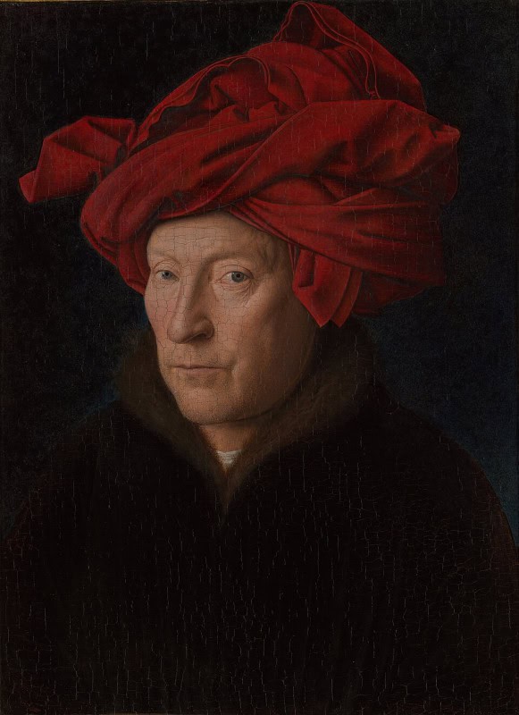 Middle-aged man against a black background wearing an elaborately folded red cloth headdress, his face lined and his eyes turned directly towards the viewer