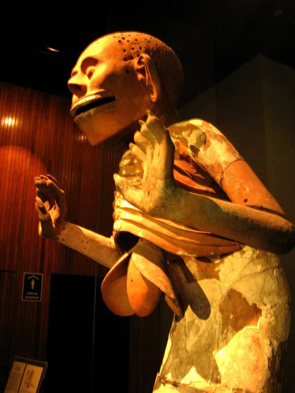 Clay figure of Mictlantecuhtli with a skeletal face and exposed ribcage, lit orange in the Templo Mayor museum