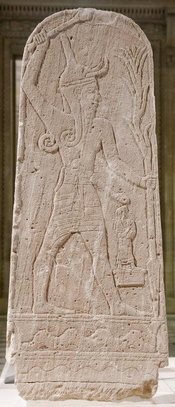 Pale limestone stele from Ugarit carved in relief with a striding figure of the storm god Baal raising a weapon