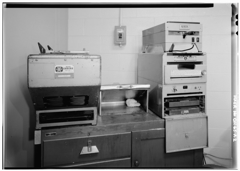 A Xerox xerographic copier installation: a metal box on a bench with a plate reading "Xerox Camera Unit No. 1" and a stacked "Xerox Processor Model D" unit at right