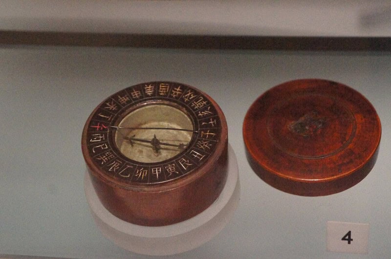 A Chinese mariner's compass of about 1760, a needle in a round lacquered case with its lid beside it
