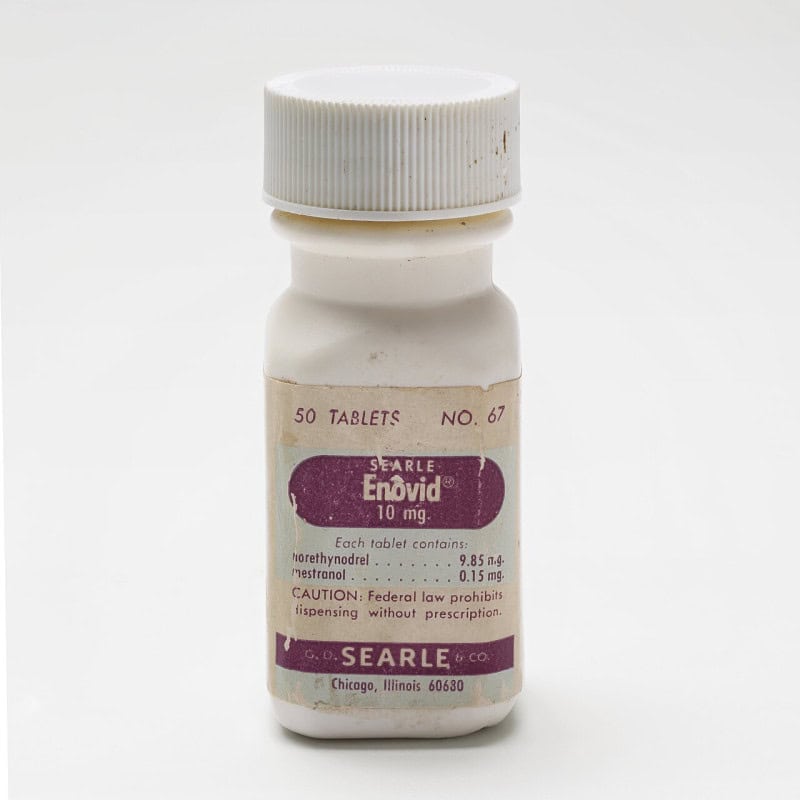 A white bottle of Enovid 10 mg oral contraceptive tablets with its printed label