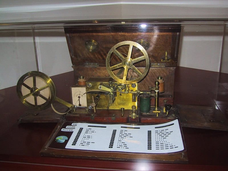 A Morse telegraph register, brass clockwork on a wooden base with a paper tape, in a French telecommunications museum