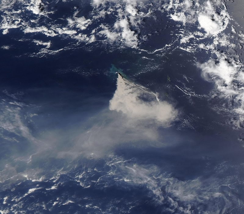 Satellite image of Nishinoshima in August 2020 with a white ash plume streaming from the island across the dark Pacific