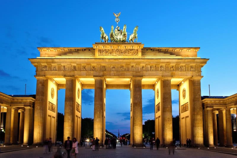 The Brandenburg Gate in Berlin lit golden at dusk, with the Quadriga on top