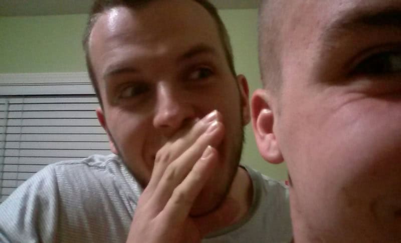 Close-up of one player cupping a hand to whisper into another player's ear in the telephone game